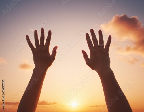 Silhouetted hands reaching up towards a vibrant sunset sky, symbolizing hope, freedom, and spirituality.