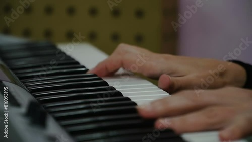 Female fingers press the keys of the piano, grand piano, synthesizer. A woman plays a melody. White and black keys. Music teacher.
