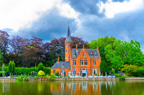 Kasteel Minnewater Lake of Love castle building in park with green trees near Minnewater Lake of Love in Brugge city historical centre, Bruges old town quarter district, Flemish Region, Belgium photo