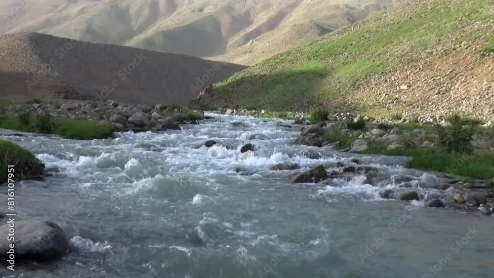 a river flowing through lush green hills, with water sourced from majestic Damavand mountain. a river flowing through lush green hills, with water sourced from majestic Damavand mountain.