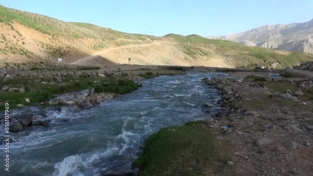 river stream flowing through a rocky path, creating waves, meandering through verdant hills, and winding its way. river stream flowing through a rocky path, creating waves, meandering through verdant hills, and winding its way.