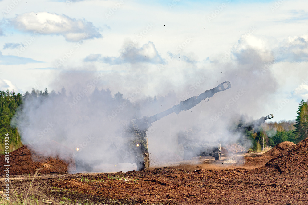Obraz premium firing self propelled howitzer in the smoke