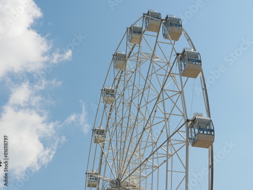 Ferris wheel against a background of blue sky and white cloud. photo