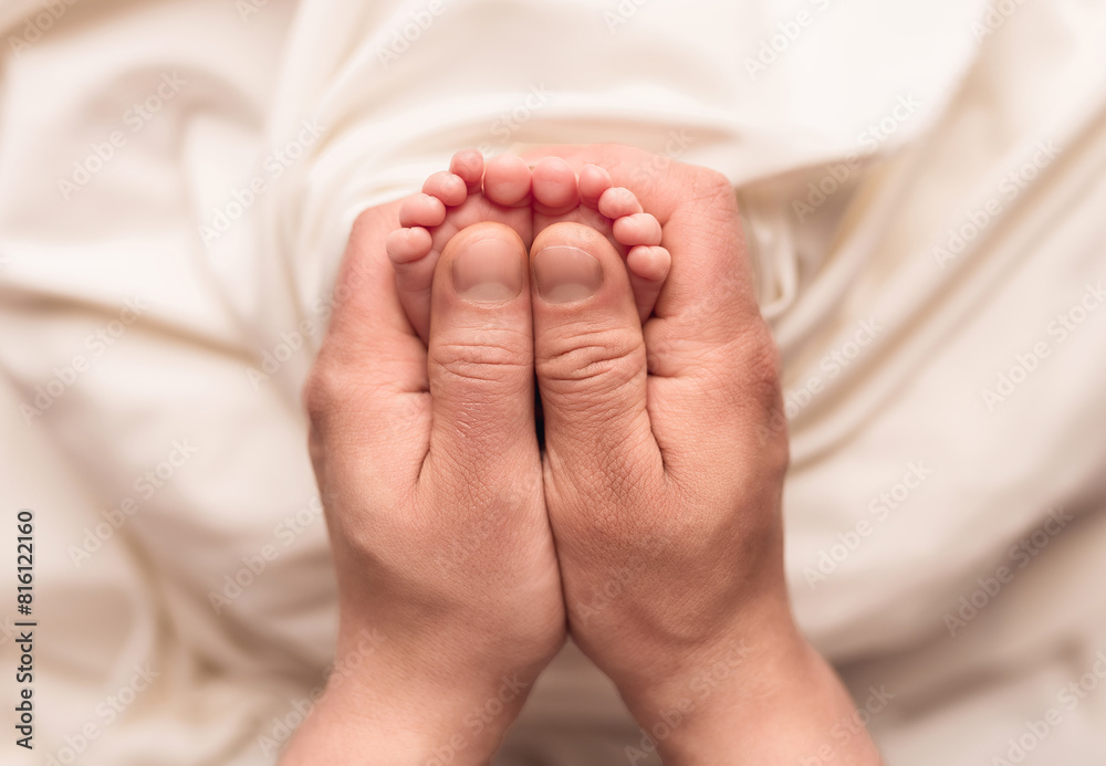 Baby feet of a newborn in dad's hands. On a white background. Baby feet of a newborn in dad's hands. On a white background.