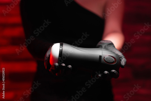 Sex toys for men. An artificial vagina for masturbation in the hands of a girl in black latex gloves and a black dress on a red background. Male massager. Sex shop Adult store