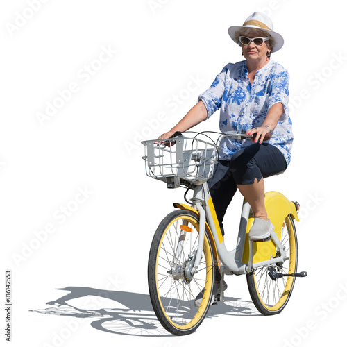 Older woman wearing a hat and colorful outfit riding a bike in summer isolated on white background