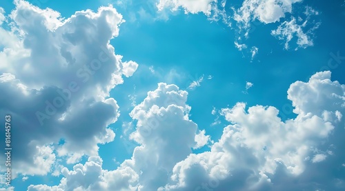 A photograph of fluffy clouds set against a blue sky, creating a serene wallpaper and abstract background