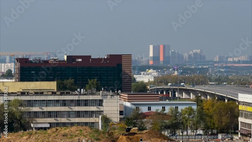 Time lapse. The big city panoramic view in a hot summer day with working excavator on the foreground