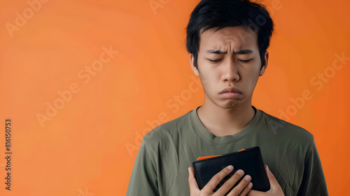 I Dont Have Money Portrait of upset asian man looking at his empty wallet Depressed sad guy standing isolated over orange studio background wall Poverty Financial Crisis And Bankruptcy : Generative AI photo