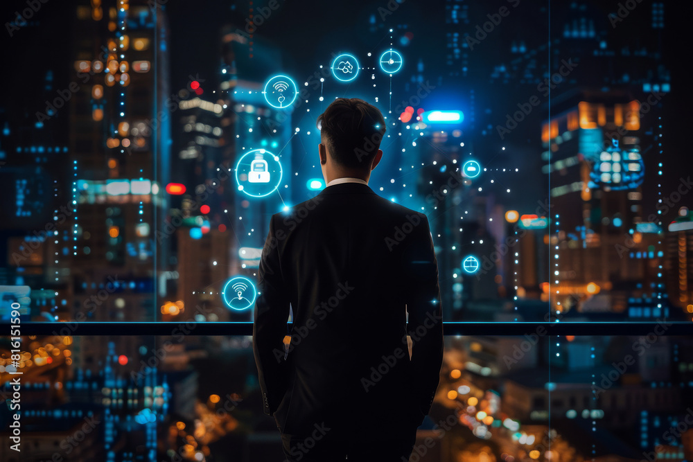 A man in a suit looks out a window at a city at night A man in a suit looks out a window at a city at night