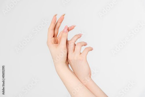 Close-up side view of elegant female hands touching each other during dance against grey background. Soft focus. Femininity and sensuality. Beauty and body care. Self expression theme.