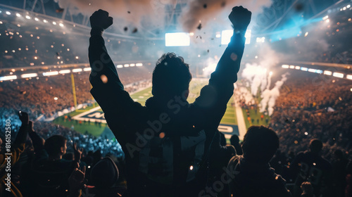 A silhouette of an excited  football fan cheering in the stands, with other fans during the finals of MLB game 