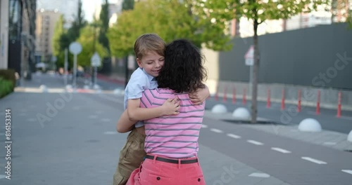 Little son running to the mother to hug. Mother and little child boy playing outdoor in the park. Happy family day concept