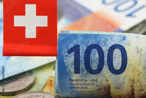 Rolled Swiss franc notes. A small Swiss flag is attached