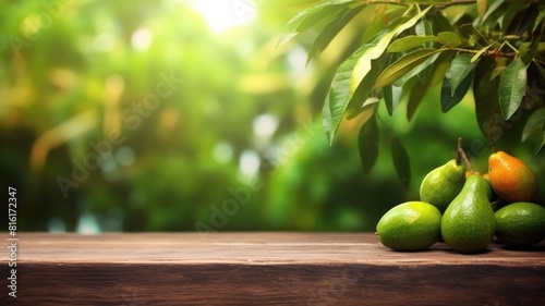 Fresh green pears on wooden table with lush foliage background or a bunch of avocados sitting on a light brown wooden table with blurring background. Natural food and healthy diet concept. AIG35.