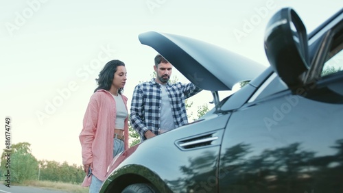 Couple looking at broken car on the road, woman using mobile phone. Slow motion © Nataliya