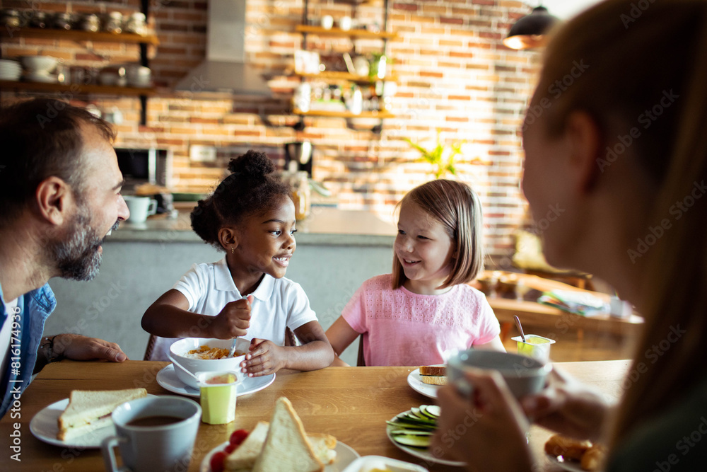 Young mixed family eating together at home