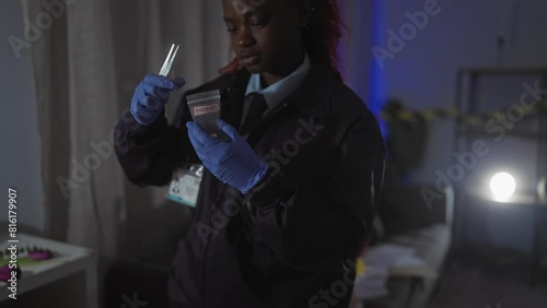 African american woman detective analyzes evidence at indoor crime scene with badge illumination living room photo