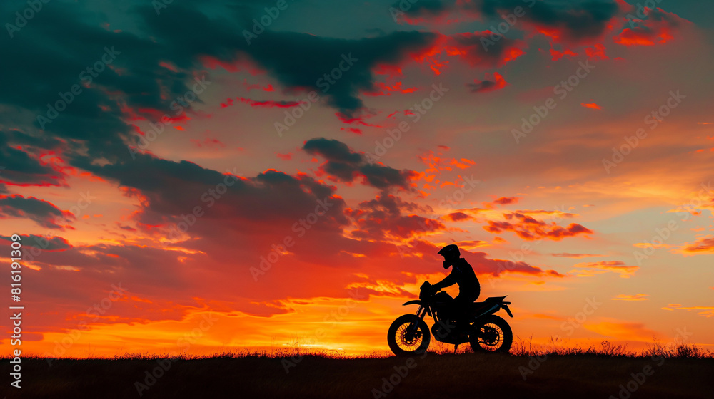 A silhouette of a biker against a stunning sunset, the outline of the bike and rider clearly defined against the colorful sky. Dynamic and dramatic composition, with copy space