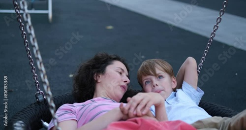 Cute caucasian brunette mother having fun with her kid son oa a playground. Outdoor activities. Family day or spending time together concept