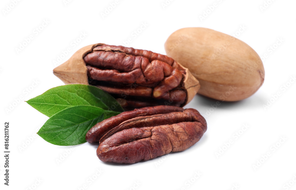 Many tasty pecan nuts with green leaves isolated on white Many tasty pecan nuts with green leaves isolated on white