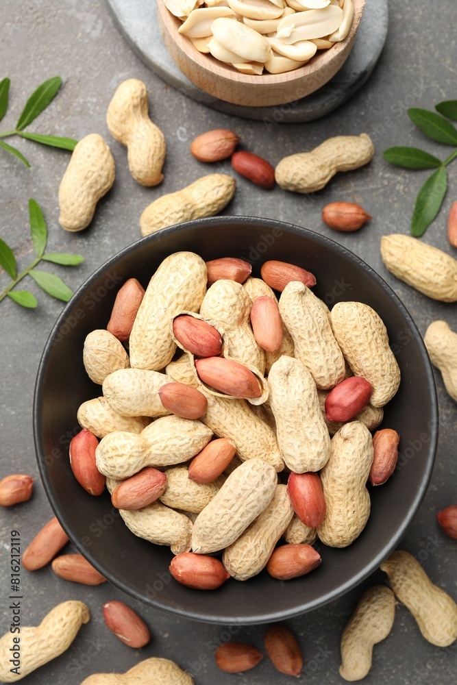 Fresh peanuts and twigs on grey table, flat lay Fresh peanuts and twigs on grey table, flat lay