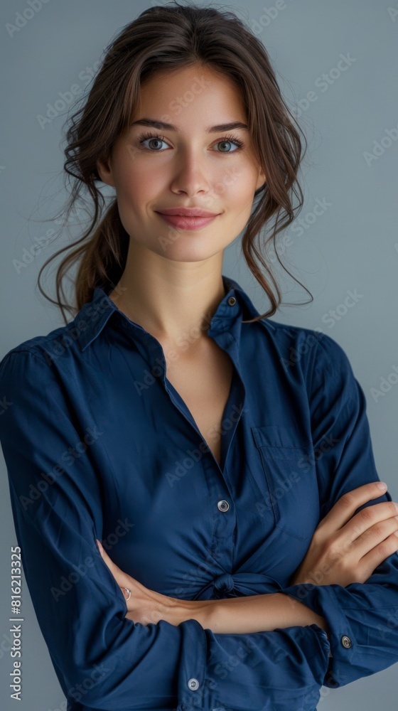 A young woman wearing a blue shirt strikes a pose while being photographed A young woman wearing a blue shirt strikes a pose while being photographed