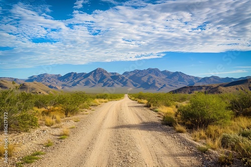 desert journey dirt road leading to distant mountains under blue sky landscape photography
