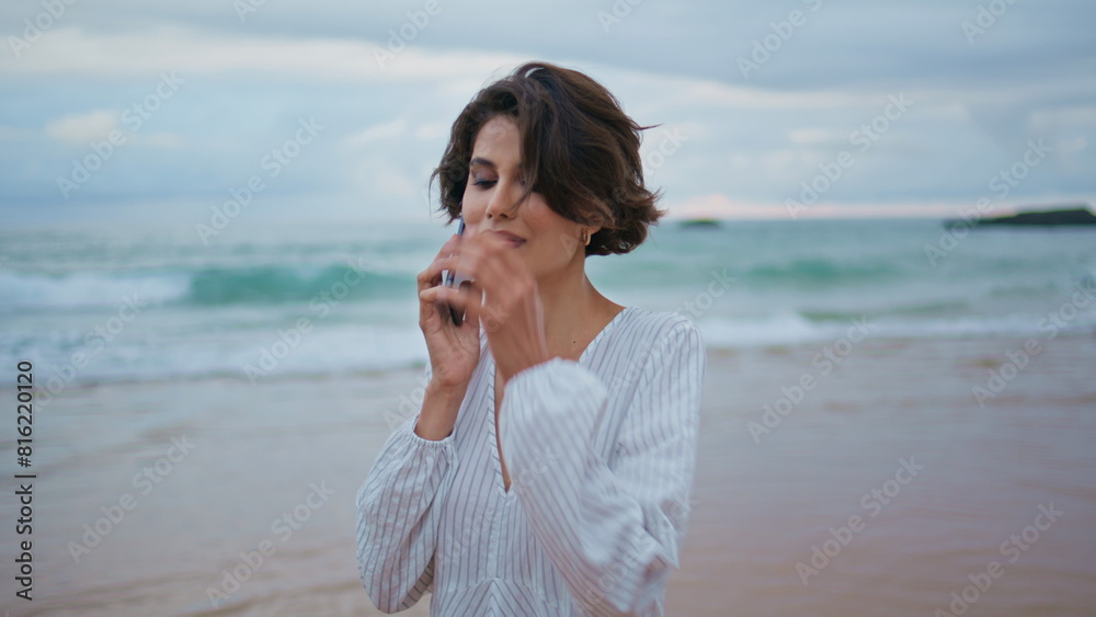 Friendly girl talking cellphone at beautiful ocean waves. Calm model going shore Friendly girl talking cellphone at beautiful ocean waves. Calm model going shore