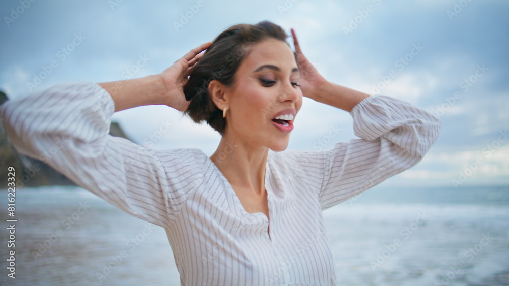 Excited woman walking ocean coast on cloudy day. Closeup smiling traveler look Excited woman walking ocean coast on cloudy day. Closeup smiling traveler look