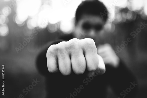 Close-up of a man's brutal fist striking a blow. criminal man striking a blow close-up. black and white filter, low key