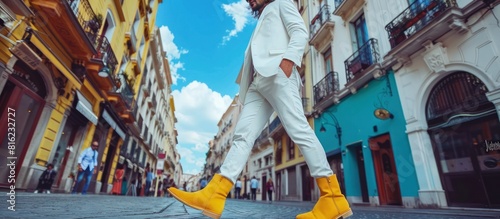 white suit and yellow boots walking down street