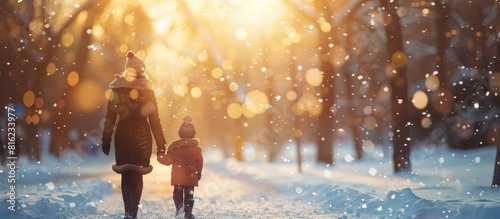 Woman and child walking through snowy forest photo
