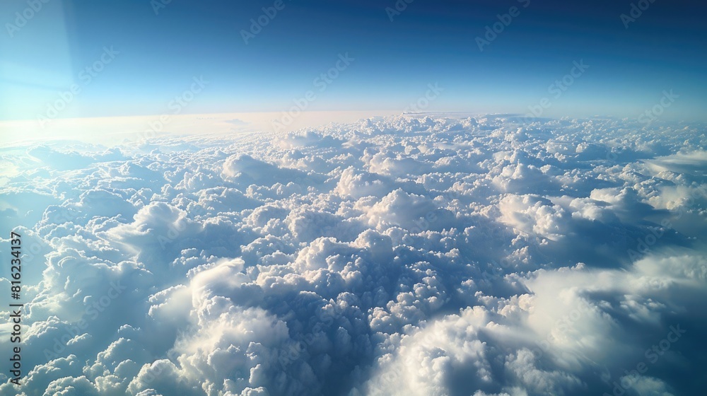 Fototapeta premium Expansive Mammatus Clouds Seen from Airplane Window with Clear Blue Sky and Sunlit Cloud Formations