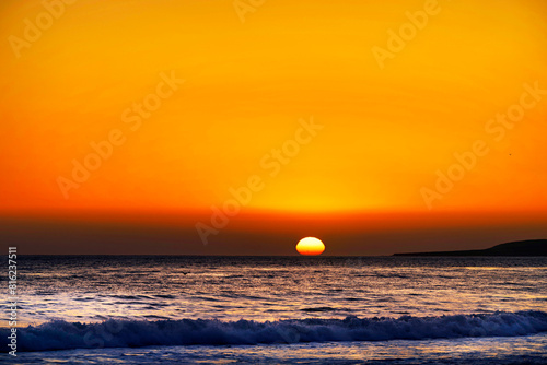 Setting sun over the ocean on the horizon