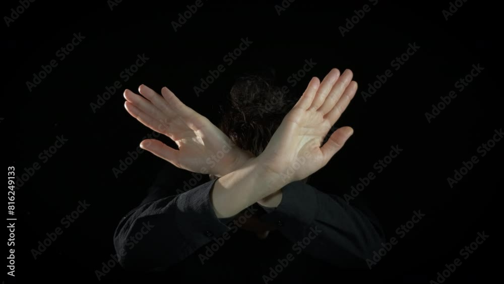 Dissatisfied female making refusal gesture. A female with dissatisfied feelings show the crossing hands no say no on the black background.