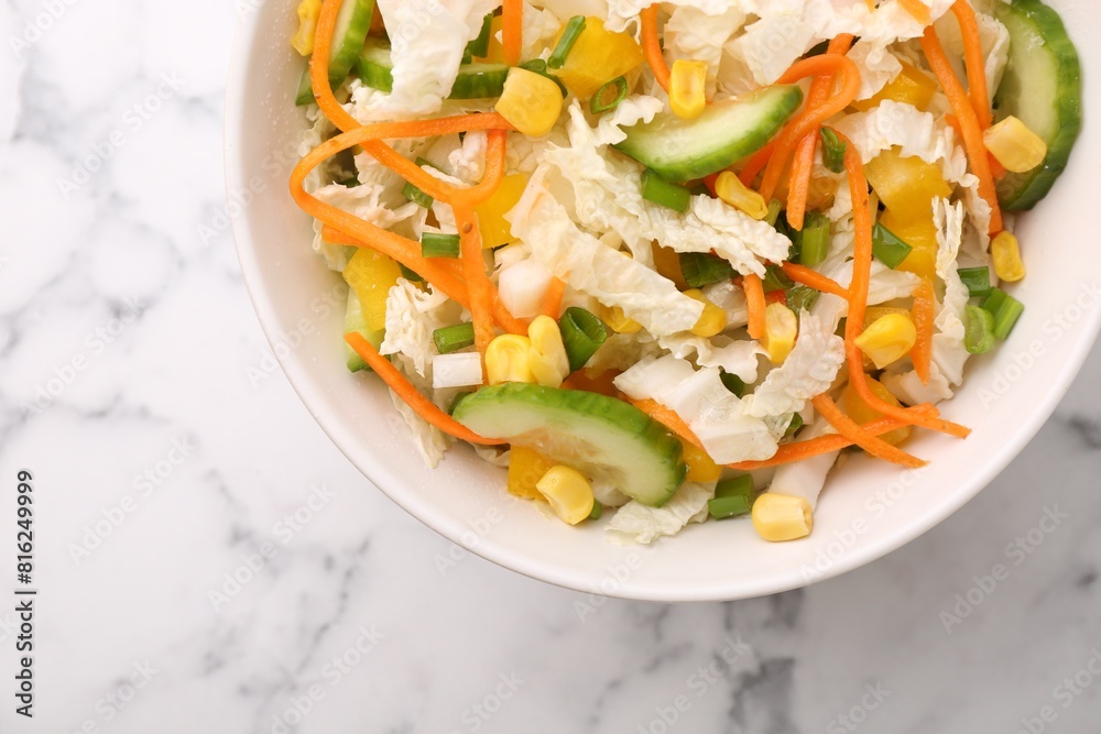Tasty salad with Chinese cabbage, carrot, corn and cucumber in bowl on white marble table, top view Tasty salad with Chinese cabbage, carrot, corn and cucumber in bowl on white marble table, top view