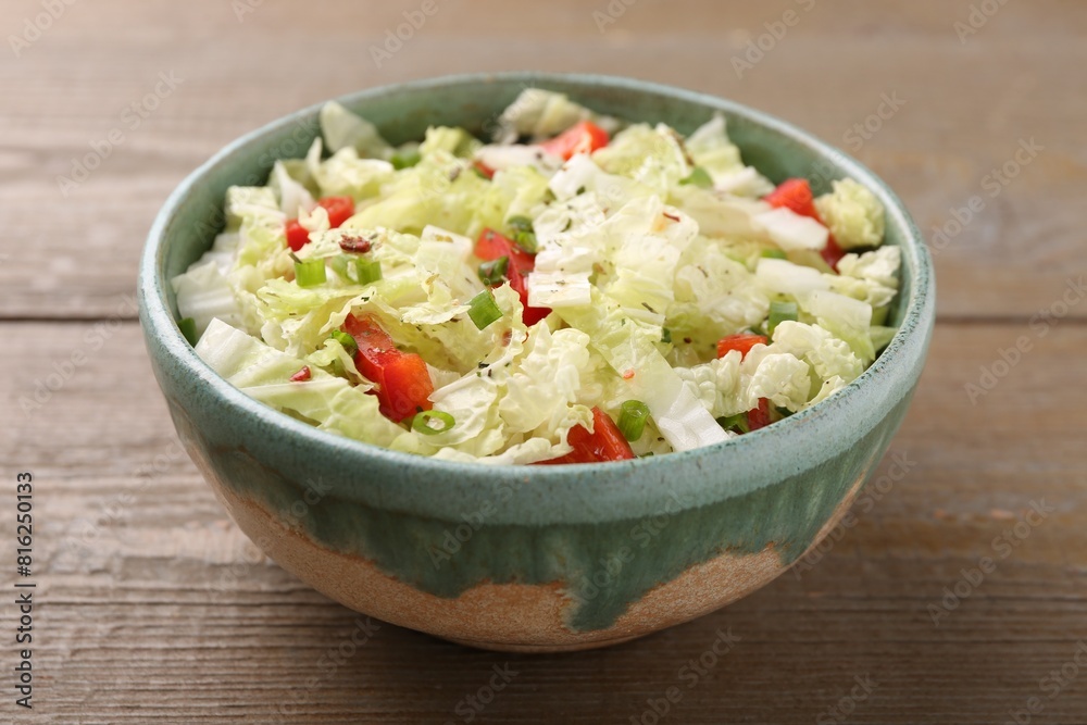 Tasty salad with Chinese cabbage, bell pepper and green onion in bowl on wooden table, closeup Tasty salad with Chinese cabbage, bell pepper and green onion in bowl on wooden table, closeup