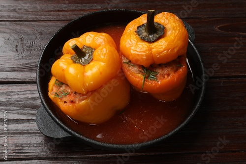 Tasty stuffed peppers in pan on wooden table  closeup