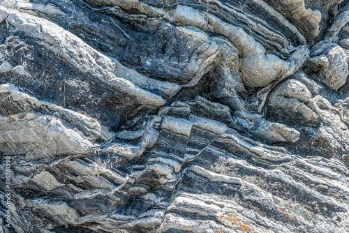 Nature force compressed prominent cracked rock layers structure formation details, in various shapes, colors, thicknesses, at south central coast of Crete, Greece. Nature Geological science concept.