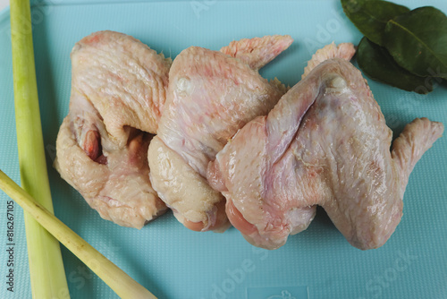 Uncooked or raw chicken wings on cutting board with ingredients.