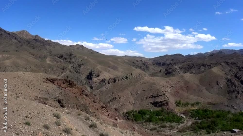 green land surrounded by majestic mountains and a rocky landscape as the lush greenery of the land stands between rugged backdrop. green land surrounded by majestic mountains and a rocky landscape as the lush greenery of the land stands between rugged backdrop.