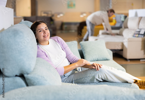 Woman trying out armchair in furniture showroom photo