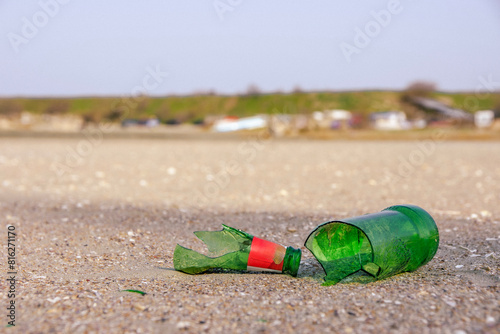 A broken glass bottle on the sand of the beach.