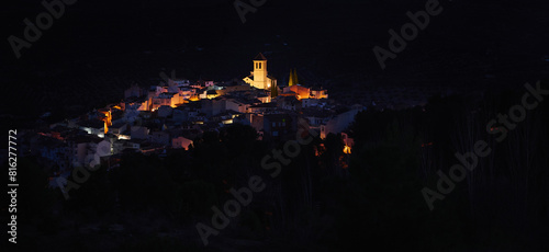 View from the hill of medieval historical city of Quesada in province of Jaen, with illuminated bell tower and while houses in the night time. Andalusia. Spain. Beauty in nature. Travel and tourism photo