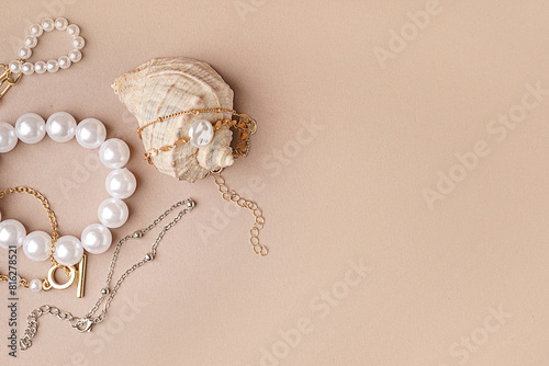 Different beautiful bracelets with seashell on pink background