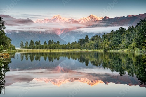 Veil clouds in front of Mount Cook and Mount Tasman are reflected in Lake Matheson in the evening light, Westland National Park, Fox Glacier, Whataroa, West Coast, New Zealand, Oceania photo