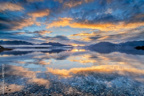 Light beam of golden cloud atmosphere over Lake Te Anau, in the background mountain ranges of the Stuart Mountains and Franklin Mountains, Fjordland National Park, Te Anau, Te Anau, Southland, New