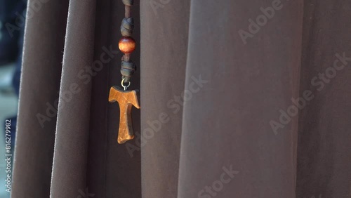 Cruz franciscana Tao de madera colgando del habito de un fraile franciscano religioso en el catolicismo, san Francisco de Asis en la religión católica photo