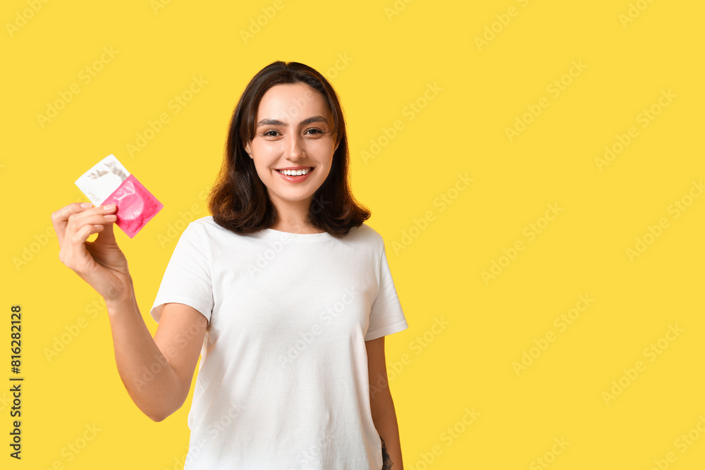 Young woman with condoms on yellow background. Safe sex concept Young woman with condoms on yellow background. Safe sex concept